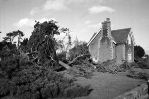 black and white phote of storm damaged old house and garden